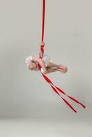 atlético hombre en un blanco deporte traje es ejecutando un acrobático elementos en un estudio. foto