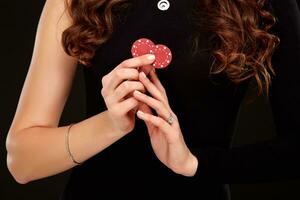 Sexy curly hair brunette posing with chips in her hands, poker concept black background photo