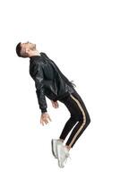 Full-length photo of a funny guy dancing in studio isolated on white background.