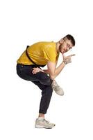 Full-length portrait of a funny guy dancing in studio isolated on white background. photo