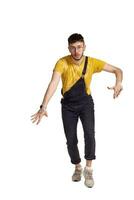 Full-length portrait of a funny guy dancing in studio isolated on white background. photo