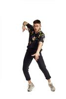 Full-length portrait of a funny guy dancing in studio isolated on white background. photo