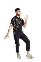 Full-length portrait of a funny guy dancing in studio isolated on white background. photo