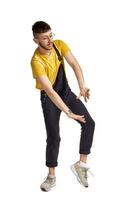 Full-length portrait of a funny guy dancing in studio isolated on white background. photo