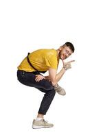 Full-length portrait of a funny guy dancing in studio isolated on white background. photo