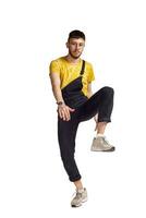 Full-length portrait of a funny guy dancing in studio isolated on white background. photo