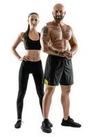 Athletic man in black shorts and sneakers with brunette woman in leggings and top posing isolated on white background. Fitness couple, gym concept. photo