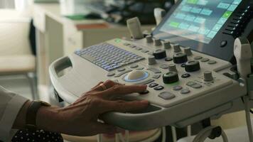 Serbien, belgrad - september 13, 2023. de kvinna läkare hand utför en medicinsk undersökning, använder sig av ett ultraljud scanner. klämma. stänga upp av ett ultraljud maskin och en läkare hand arbetssätt på Det. video