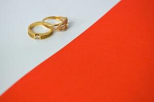 Close Up Golden ring with diamond on diagonal white and orange background photo