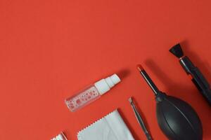 Cleaning set for camera air blower, microfiber, brush and more. Isolated on red background photo