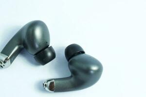 Silver wireless headset or earphone is called TWS, true wireless strereo for playing music without cable jack audio isolated on whote background photo