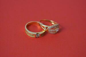 cerca arriba dorado anillo con diamante en aislado rojo antecedentes foto