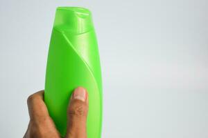 Green blank bottle shampoo minimalist bakcground, hair care bottle mock up product. photo