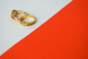 Close Up Golden ring with diamond on diagonal white and orange background photo