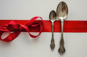 AI generated a silver spoon and fork are next to a red ribbon photo