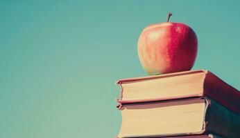 AI generated an apple on top of a stack of books with blue sky photo