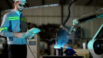 usine ingénieurs en utilisant intelligent contrôle à contrôle le bras robot machine pour Coupe le métal feuille. spécialiste ouvrier travail à la taille La technologie industrie pour produire le électronique partie appareil. video