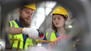 trabalhadores digitalização máquina aço peças. Operação trabalhadores verificação e inspecionando carga para pilha Itens para envio. Supervisor e funcionários trabalhando dentro fábrica armazém discutir sobre partes inventário. video