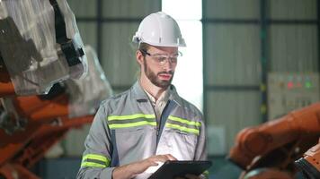 usine homme ingénieur inspecter sur machine avec intelligent tablette. ouvrier travaux à lourd machine robot bras. artificiel intelligence concept. spécialiste ouvrier travail à la taille La technologie industrie. video