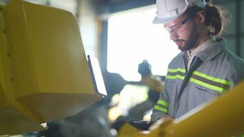 Factory man engineer inspecting on machine with smart tablet. Worker works at heavy machine robot arm. Artificial intelligence concept. specialist Worker working at height technology industry. video