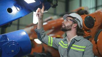 usine homme ingénieur inspecter sur machine avec intelligent tablette. ouvrier travaux à lourd machine robot bras. artificiel intelligence concept. spécialiste ouvrier travail à la taille La technologie industrie. video