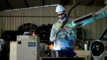 fabbrica ingegneri utilizzando inteligente controllo per controllo il braccio robot macchina per taglio il metallo foglio. specialista lavoratore Lavorando a altezza tecnologia industria per produrre il elettronico parte dispositivo. video