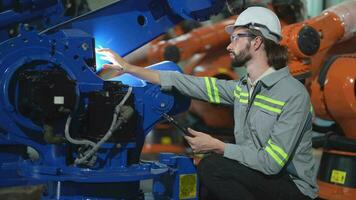 fabbrica uomo ingegnere ispezionando su macchina con inteligente tavoletta. lavoratore lavori a pesante macchina robot braccio. artificiale intelligenza concetto. specialista lavoratore Lavorando a altezza tecnologia industria. video