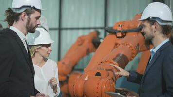 o negócio engenheiros Conheça e Verifica ao controle pesado máquina robô braço. diverso equipe do industrial robótica engenheiros colhido por aí máquina. profissional maquinaria operador usar industrial digital tábua. video