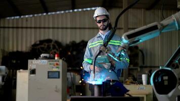 fábrica ingenieros utilizando inteligente controlar a controlar el brazo robot máquina para corte el metal hoja. especialista trabajador trabajando a altura tecnología industria para Produce el electrónico parte dispositivo. video