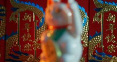 Maneki Neko chinois chat contre une rouge Contexte video