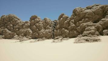 A group of rocks sitting on top of a sandy beach video