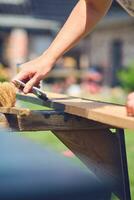 Painting a piece of Wood with a brush photo