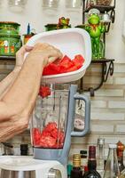 profesional cocinero prepara gazpacho en licuadora a hogar cocina con experto manos foto