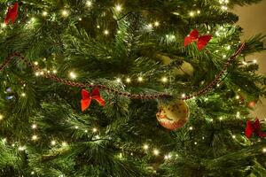 de cerca de Navidad árbol con adornos y guirnalda con luces foto