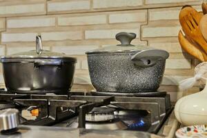 Busy Kitchen Scene with Pots, Lids, and Gas Stove Cooking Food at Home photo