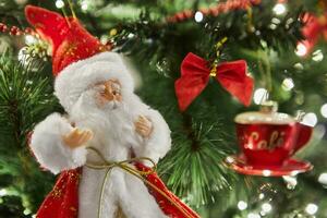 Close-up of a Christmas tree with Santa Claus, decorations and garlands with lights photo