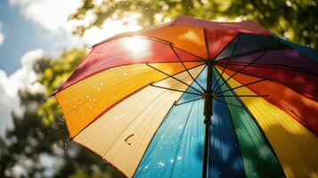 ai generado arco iris paraguas con agua gotas en contra luz de sol foto