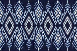 étnico azul y blanco ikat modelo en oscuro azul antecedentes. sin costura modelo vector diseño para tela, teja, alfombra, bordado, fondo de pantalla y antecedentes