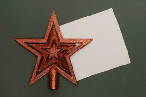 Christmas star with blank card on dark background. Top view with copy space photo