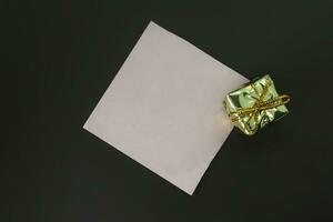 gift box and blank paper on the black background, top view photo