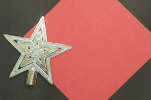Christmas silver star on a red and black background with copy space photo