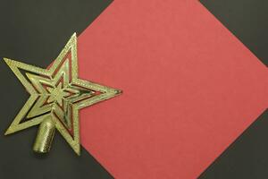 Christmas golden star on red paper with copy space for text on black background photo