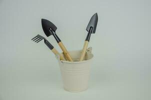 Garden tool in a white bucket on a light background photo