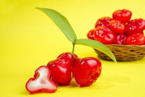 fresh water apple fruit and some water apple on basket behind on yellow background photo