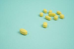 amarillo tableta medicina en aislado azul antecedentes foto