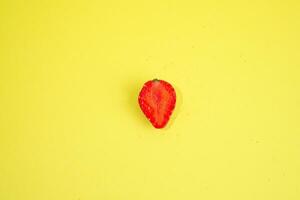 Half single strawberry isolated on yellow background photo