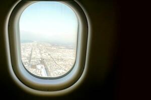 Closeup window in the airplane with blue and higher of landscape view background. photo