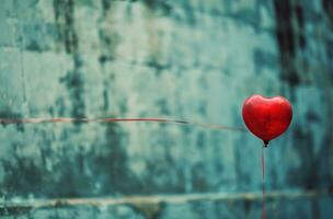 ai generado un rojo corazón globo en el aire con un rojo línea a través de eso foto