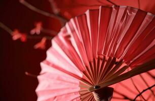 ai generado un rosado origami ventilador cuelga en un rojo antecedentes foto