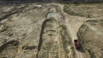 Top view of truck driving on rural road. Scene. Dump truck rides on dry yellow quarry road in summer. Heavy machinery on construction and quarry roads photo